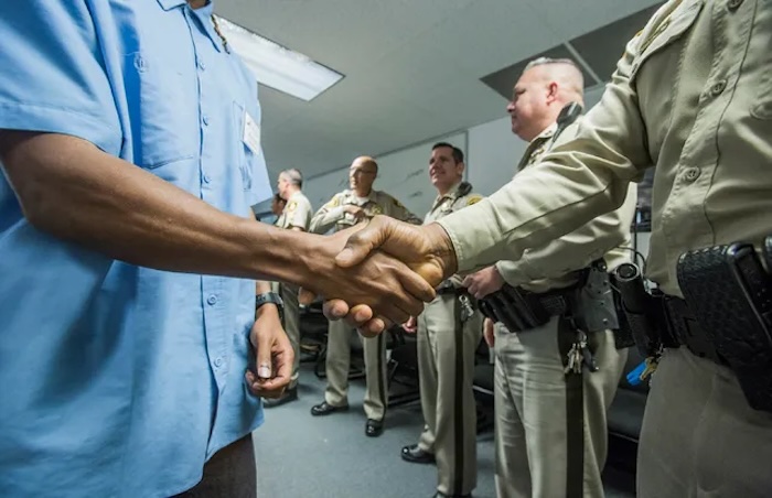 Inmate and guard shake hands